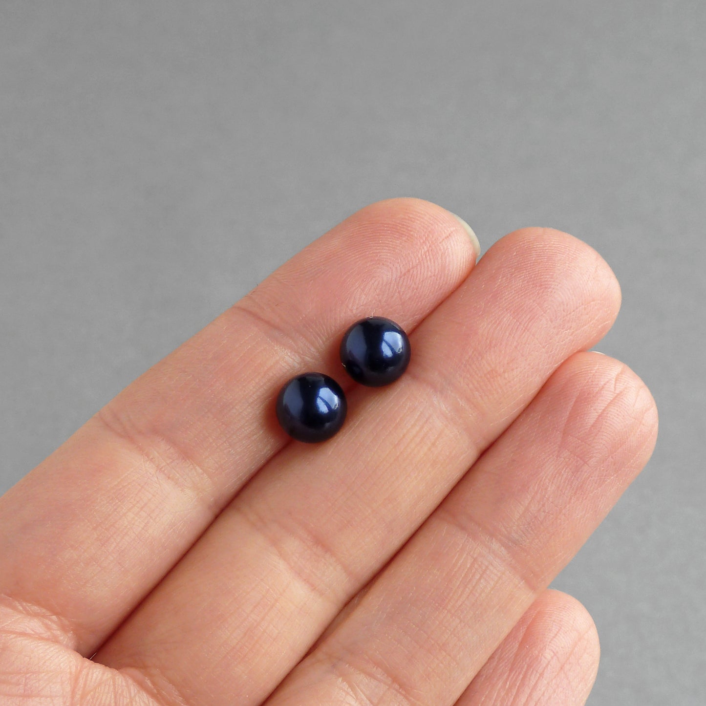 Round dark blue pearl stud earrings