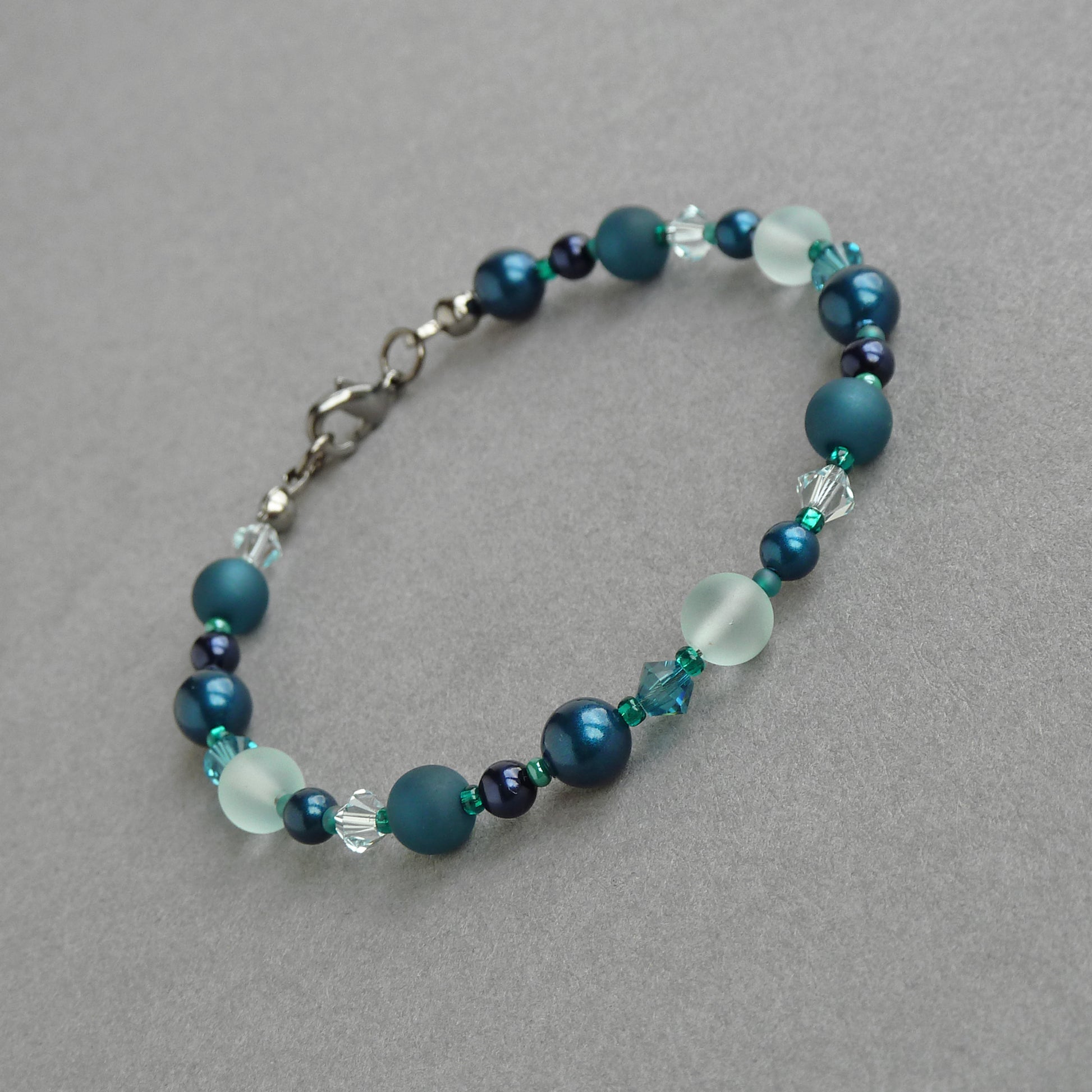 Blue green beaded bracelets. Teal, navy and aqua pearl, crystal and sea glass bracelet