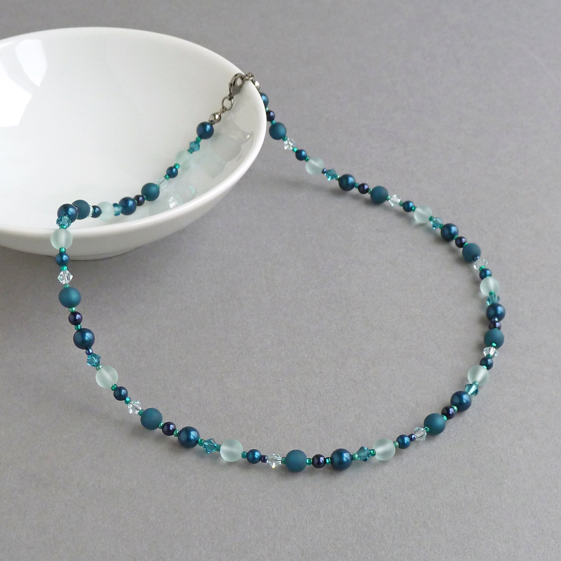 Teal beaded necklace made with pearls and crystals.