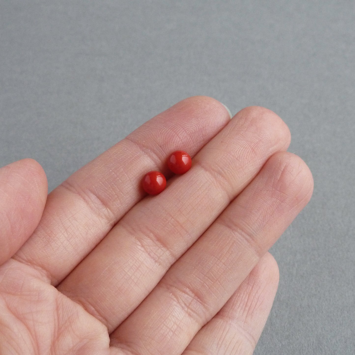 Small coral red stud earrings